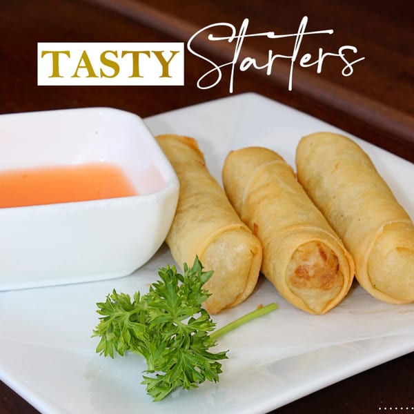 Three crispy Thai spring rolls with sweet chili dipping sauce and parsley on a white plate.